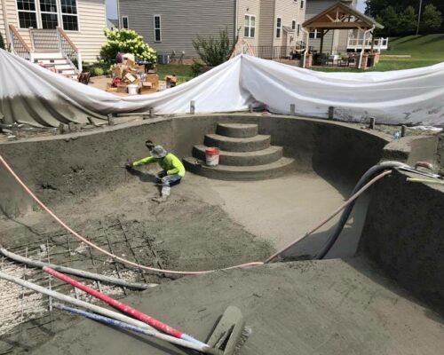 concrete-pool-construction-man-shaping-concrete