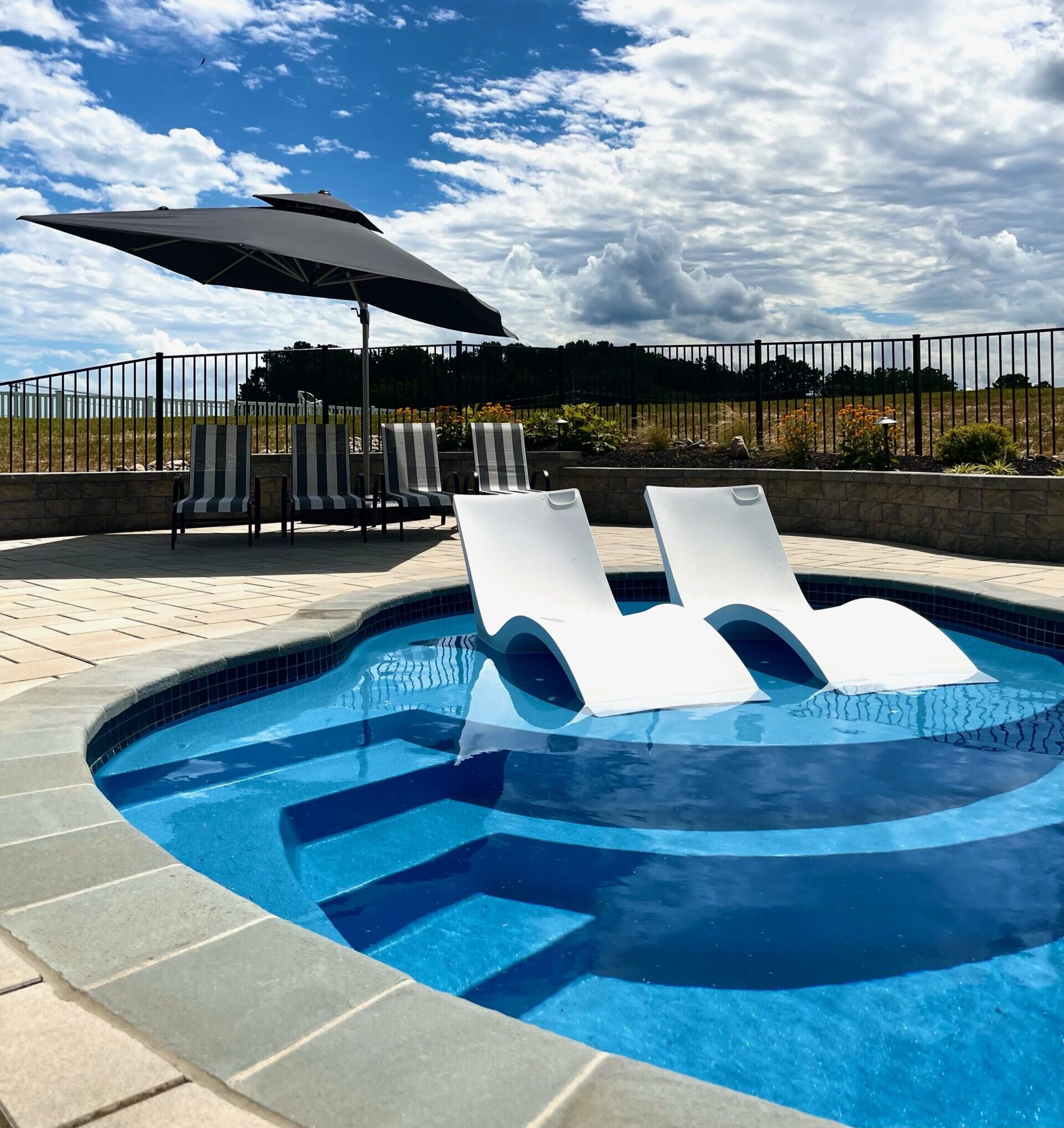 Sunshelf on a fiberglass pool installation with loungers